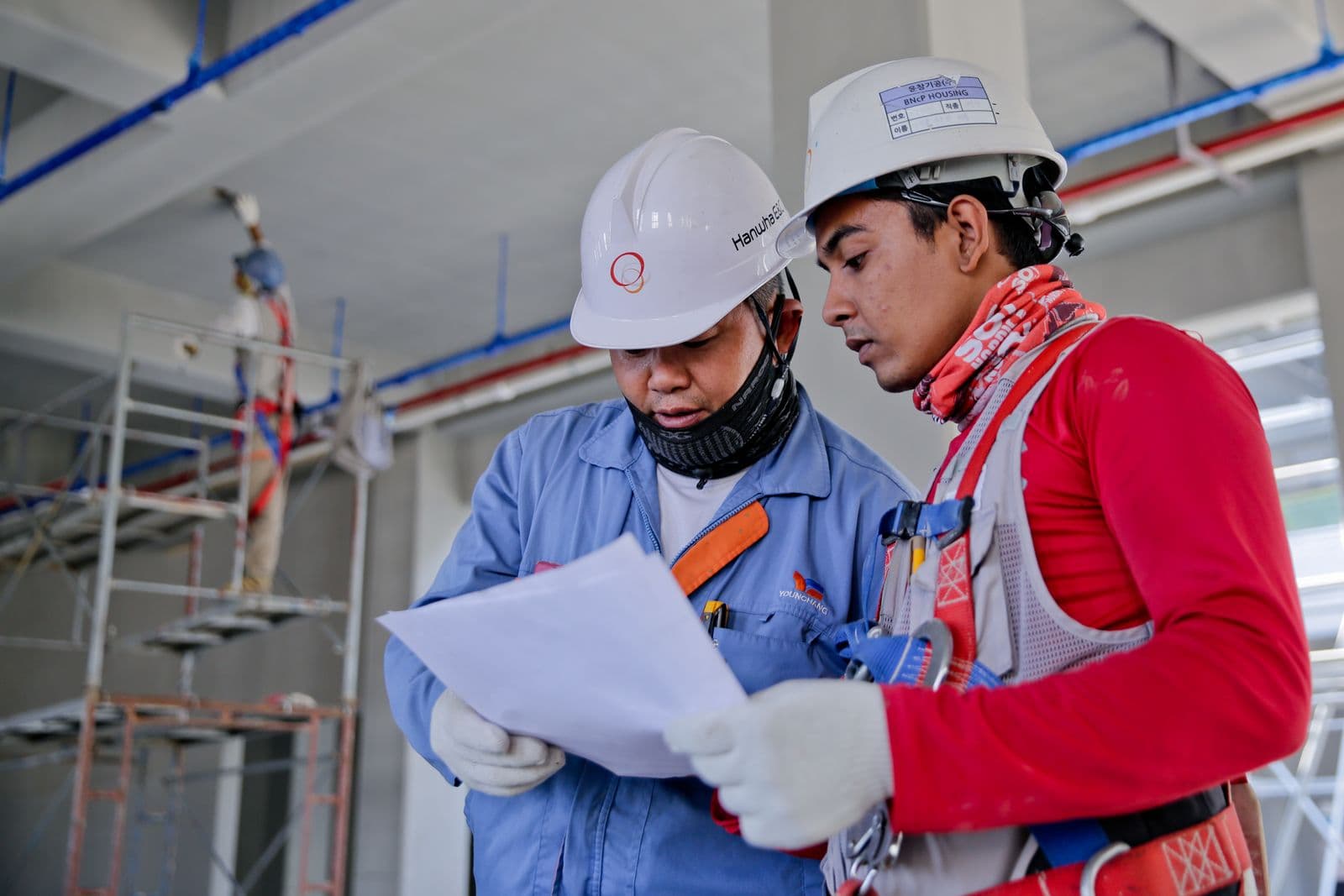 Ingenieros con casco revisando planos en una obra de construcción — Diseño de proyectos HVAC en Bucaramanga y Barranquilla