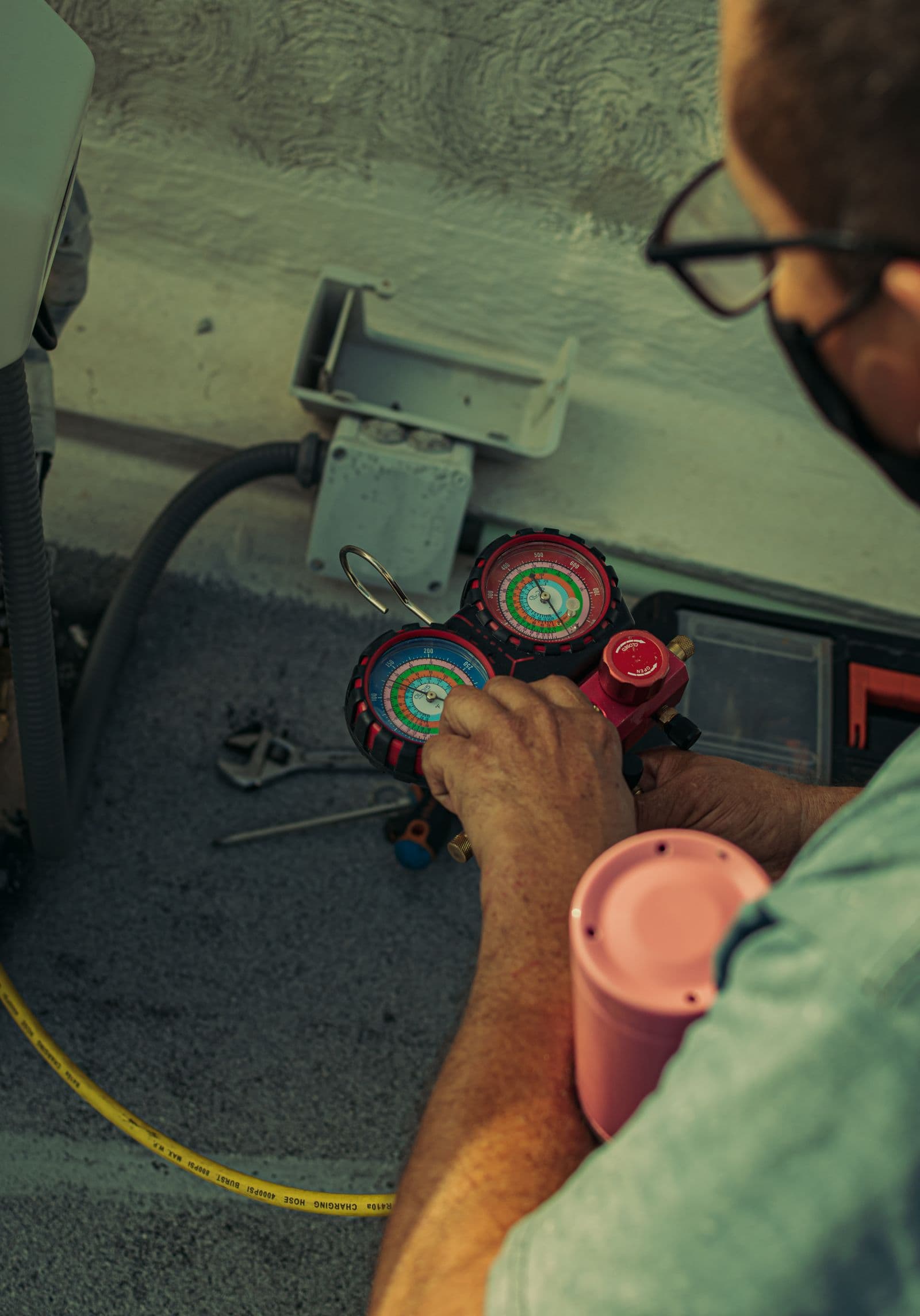 Técnico midiendo presiones de refrigerante con manómetros en un aire acondicionado — instalación y mantenimiento de aire acondicionado en Bucaramanga y Barranquilla